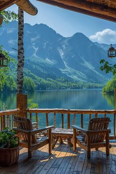 two wooden chairs sitting on top of a wooden deck next to a body of water