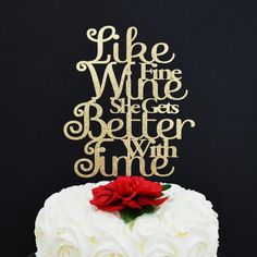 a cake with white frosting and red flowers on top that says life wine, she gets better time