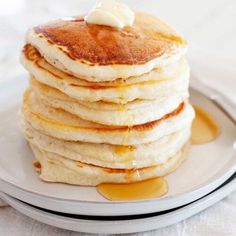 a stack of pancakes on a plate topped with butter and syrup, ready to be eaten