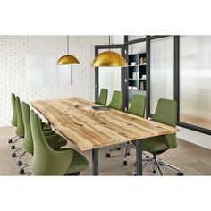 a wooden table surrounded by green chairs in an office