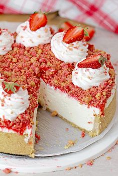 a cake with strawberries and whipped cream on top sits on a plate, ready to be eaten