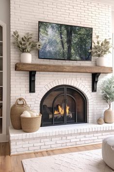 a living room with a fire place and tv on the wall above it, along with potted plants