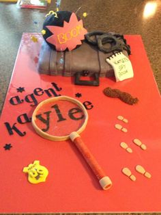 a birthday cake made to look like a magnifying glass with the words agent kayle on it