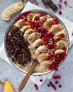 a bowl filled with oatmeal topped with bananas and pomegranate