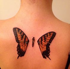 two butterflies on the back of a woman's shoulder