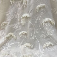 an embroidered fabric with white flowers on it