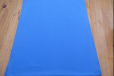 a blue table runner sitting on top of a wooden floor