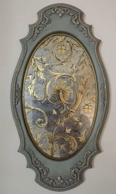 an ornate gold and silver mirror hanging on the wall