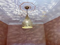 a ceiling light hanging from the ceiling in a room with brown walls and white trim