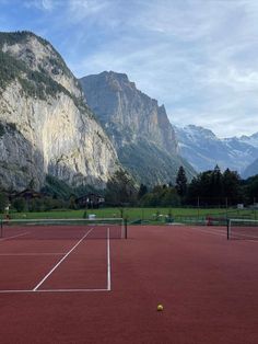 a tennis court with mountains in the background