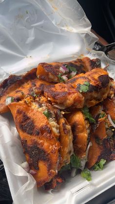 some food that is sitting on top of a white tray with plastic wrapping around it