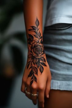 a woman's arm with a rose tattoo on the left side of her hand