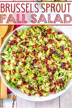 brussels sprout salad in a white bowl with pomegranates and cranberries