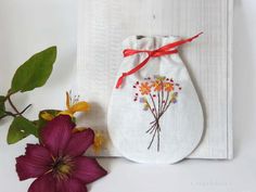 "This Pouch is perfect for several uses. Drawstring pouch bag or keepsake jewelry bag or wedding guest bag. The fabric is a linen in natural color and lined with floral liberty fabric. The pattern is a floral pattern embroidered with silk ribbon, in a chic cottage and country design, in bright hues  The pouch is closed at the top by a satin drawstring. It can be a perfect gift for who loves flowered  and romantic design. This pouch is totally handmade . **This listing is for one bag.** If you wo Embroidered Pouch Bag As Gift, Gift Pouch Bag, Rectangular Machine Embroidered Bag For Gift, Rectangular Machine Embroidered Bags For Gifts, Rectangular Bags With Machine Embroidery For Gifts, Handmade Bag For Mother's Day Gift, Handmade Bags For Mother's Day Gift, Wedding Guest Bags, Linen Pouch