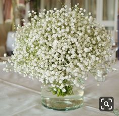 a vase filled with white flowers on top of a table