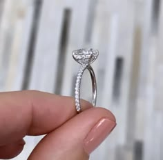 a person holding a diamond ring in their hand