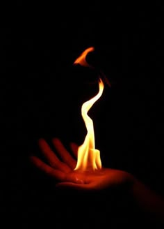 a person holding a lit candle in their hand with the flame coming out of it