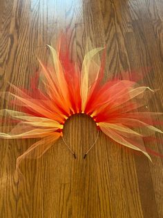 an orange and yellow flower on top of a wooden floor