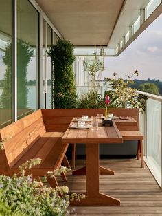 a wooden bench sitting on top of a wooden floor next to a table and chairs