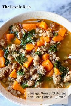 a white bowl filled with sausage, sweet potato and kale soup