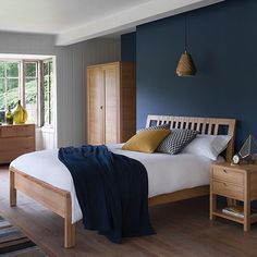 a bed room with a neatly made bed and blue walls