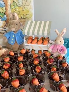 a table topped with cups filled with chocolate covered strawberries and stuffed animals sitting next to each other