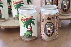 several cans of beer are sitting on a table with an owl and palm tree in the background