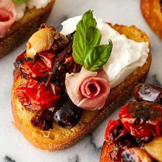 bread topped with fruit and whipped cream on top of a marble countertop next to other pastries