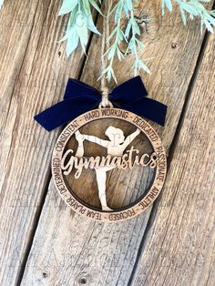 a wooden ornament with a blue ribbon hanging from it's side on a wood surface