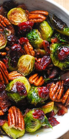 brussel sprouts with pecans, cranberries and pecans in a white bowl