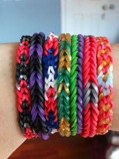 a person's arm with several different colored bracelets on it