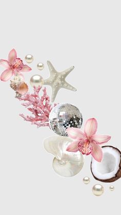 some pink flowers and pearls are on the table next to a mirror ball, starfish, and seashells