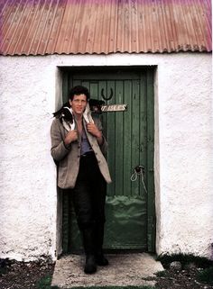 a man standing in front of a green door