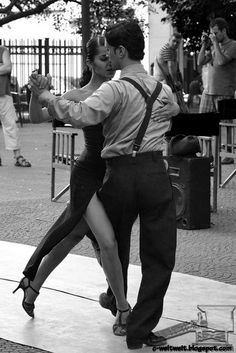 a man and woman dancing on the street