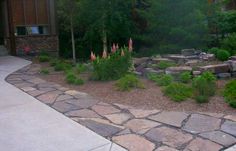 a stone path leading to a house with trees in the background