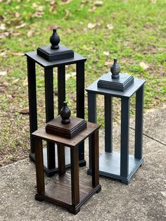 three black and brown vases sitting next to each other on top of a sidewalk