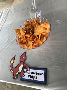 a plate of nachos and chips on a table with a sign that says charmelon chips