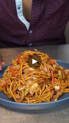 a person sitting at a table with a plate of food in front of them,