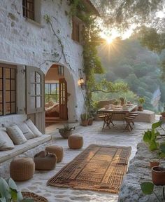 the sun is setting in front of an old house with stone walls and flooring