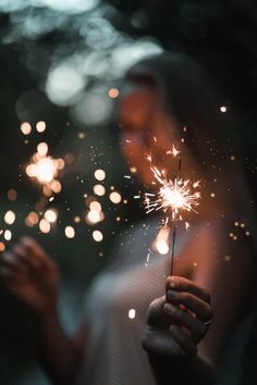 a woman holding a sparkler in her hand