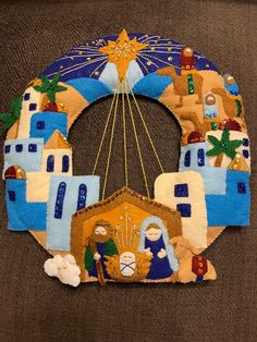 a christmas wreath made out of felt with nativity scene on the front and sides