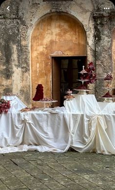 the table is covered with white cloths and red flowers