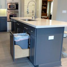 a kitchen with an island, sink and oven in the center is open for storage