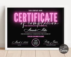 a black and pink certificate is displayed on a wooden floor with the words, your company name