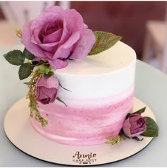 a white and pink cake with flowers on top