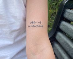 a person with a tattoo on their arm that says meet me in montauk