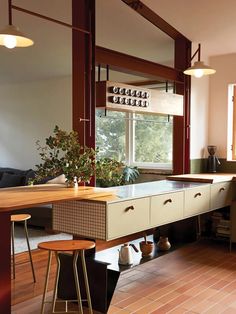 a kitchen with an island and stools next to a table in front of a window