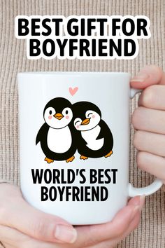 a person holding a coffee mug with two penguins on it and the words best gift for boyfriend