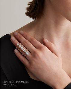 a woman's hand wearing a gold ring with three baguettes on it