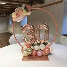 the table is decorated with flowers and balloons in the shape of numbers, which spell out the number thirty